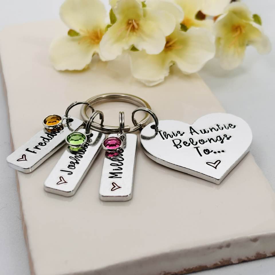 This Auntie Belongs To keyring photographed at an angle, showing the heart charm, three personalised name tags and birthstone charms
