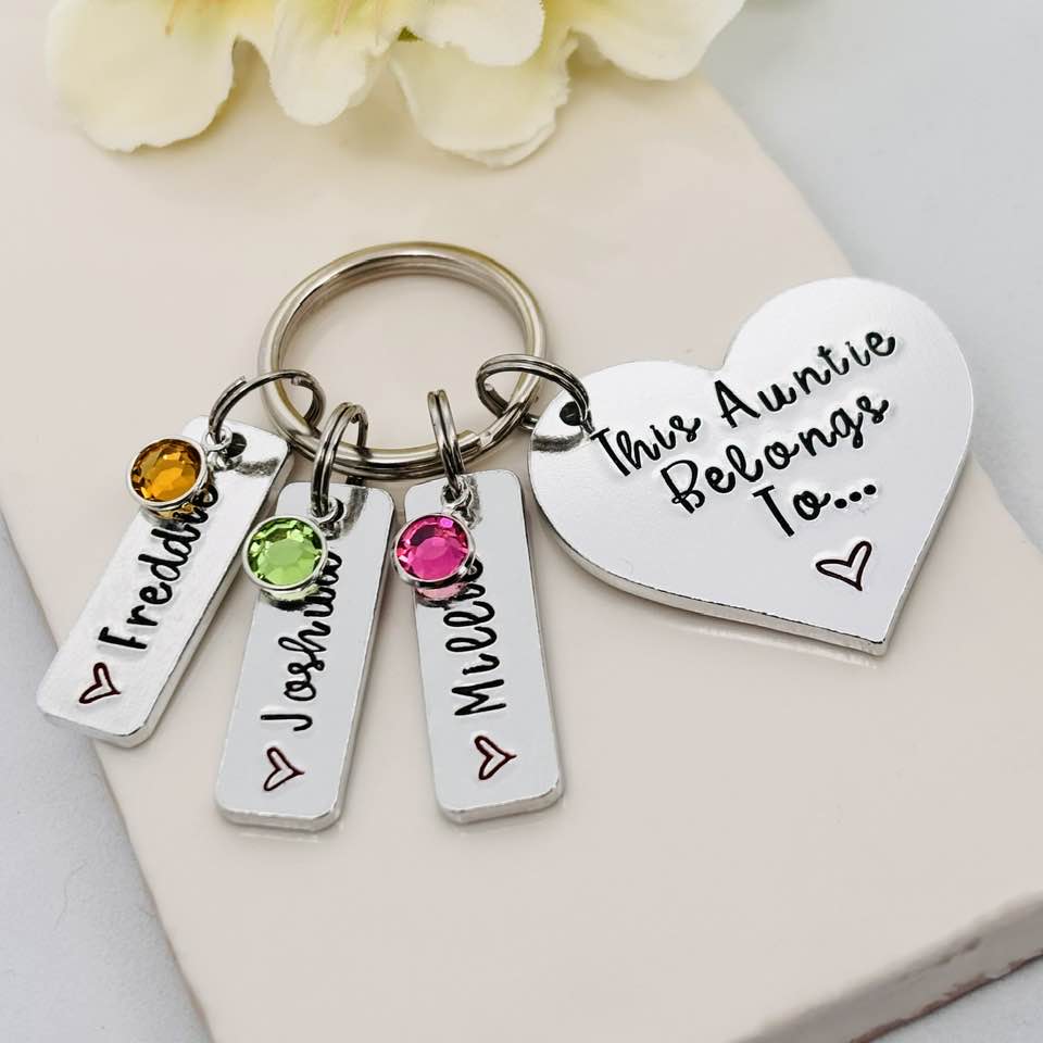 Close-up of a This Auntie Belongs To heart keyring with Freddie, Joshua and Millie name tags and yellow, green and pink birthstone charms