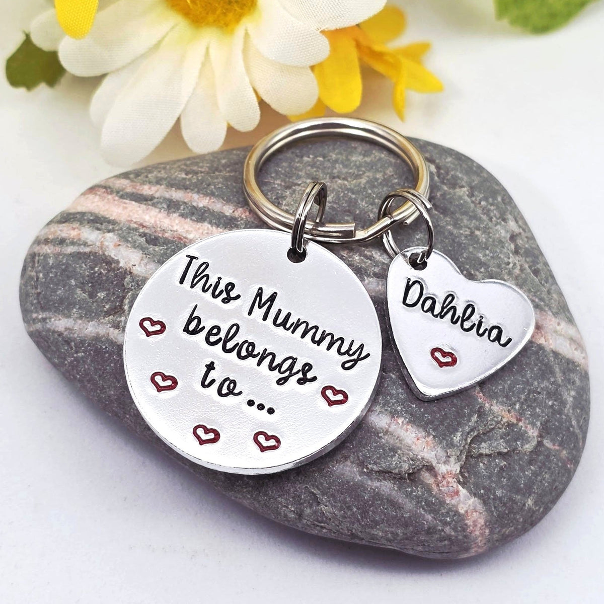 A silver metal keychain with a round hand stamped disc reading 'This Mummy belongs to.