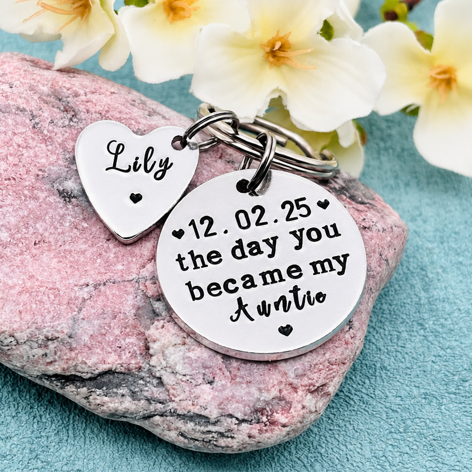Personalized silver metal keychain with a heart-shaped charm reading 'Lily' and a round disc charm hand stamped with '12.02.