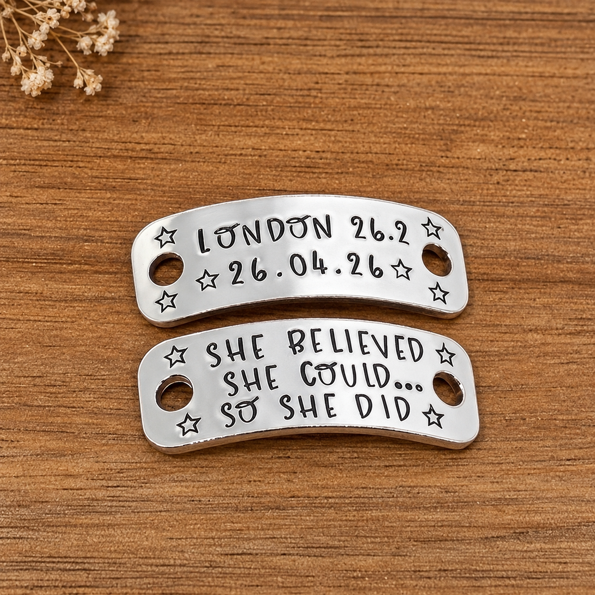 Personalised running shoe tags stamped with London 26.2 race details and She believed she could so she did, decorated with stars on wood
