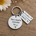 A silver metal keychain with a round disc charm reading 'This Auntie belongs to.