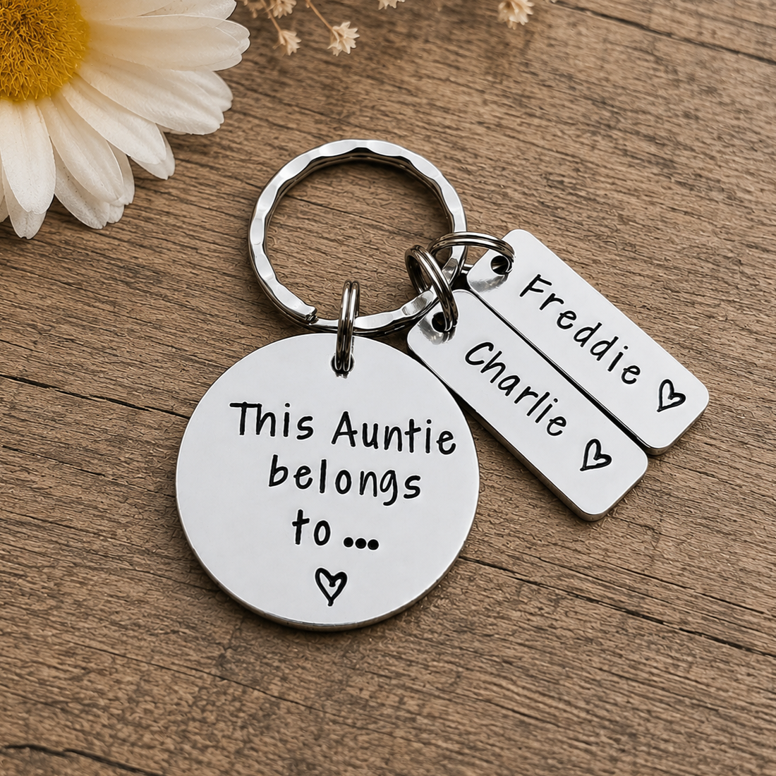 A silver metal keychain with a round disc charm reading 'This Auntie belongs to.