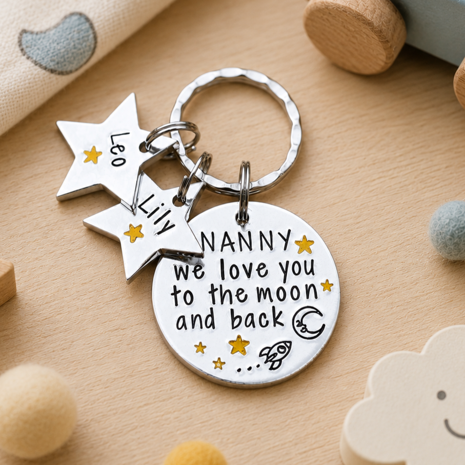 Nanny moon and back keyring with Leo and Lily star name tags, shown on a wooden surface with toys.