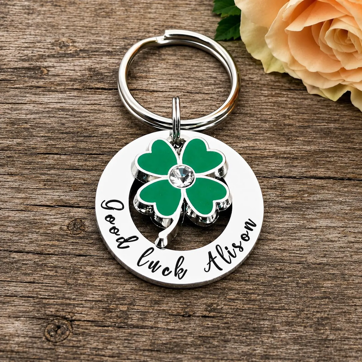 Personalised Good luck Alison washer keyring with a green four-leaf clover charm on rustic wood
