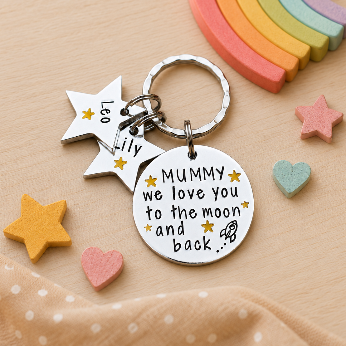 Personalised Mummy moon and back keyring with star name tags beside pastel rainbow, heart and star decorations