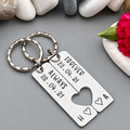 Personalised Forever and Always keyring set with date 22.04.21, initials A and H and a shared heart cut-out beside pebbles and a pink flower
