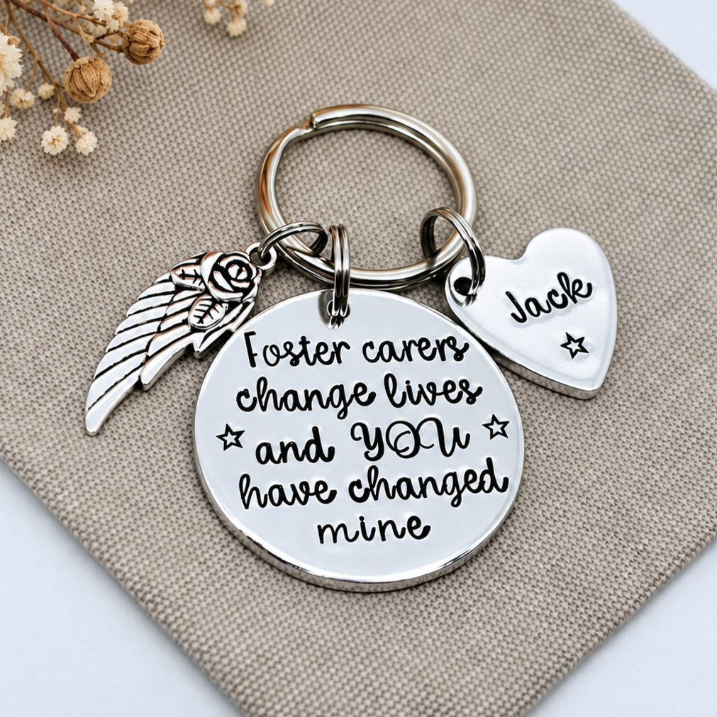 Personalised foster carer thank you keyring with a Jack heart name tag and decorative wing charm on beige fabric