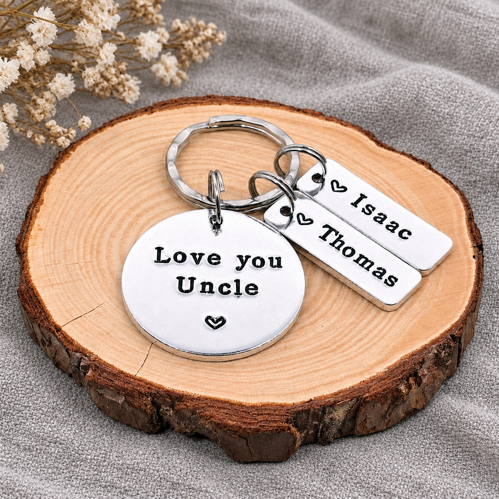 Personalized silver metal keychain with a round hand stamped disc reading 'Love you Uncle' and two rectangular tags with names 'Isaac' and 'Thomas'