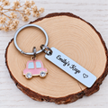 Emily's Keys personalised stainless steel keyring with outlined heart and pink car charm on wood
