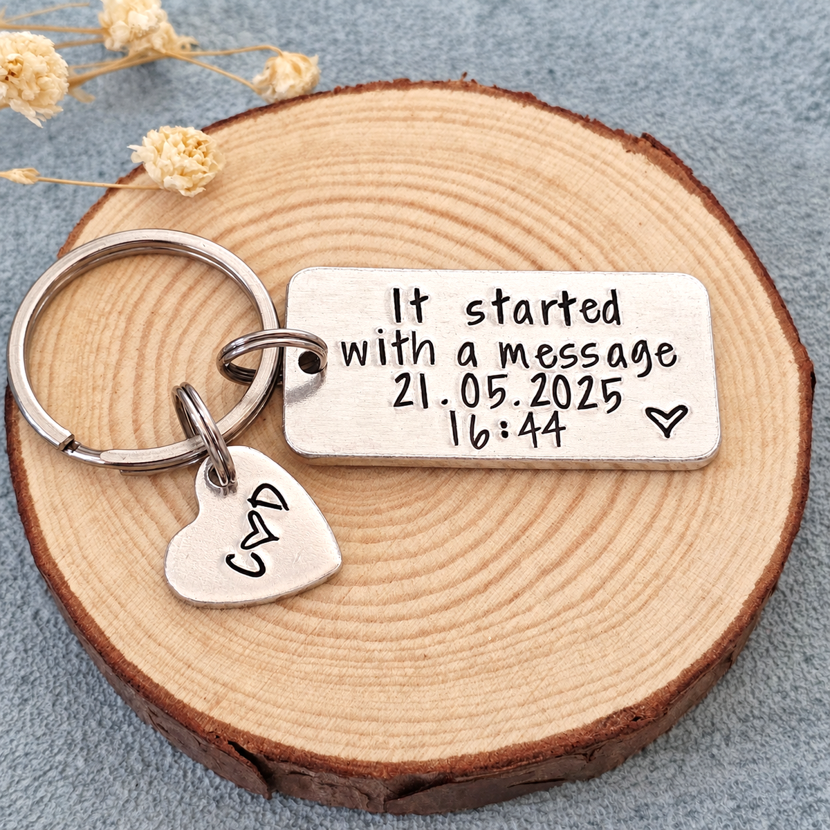 Front view of an It Started With a Message keyring with a personalised date, time and heart tag on a wood slice

