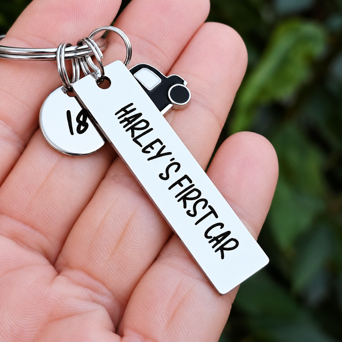 Personalised first car keyring with an 18 age tag and black car charm held in a hand