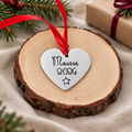 Personalised aluminium heart Christmas tree decoration stamped Maisie 2026 with a star and red ribbon, displayed upright on a wood slice
