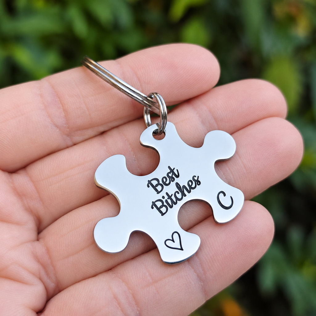 Best Bitches puzzle keyring with initial C and an outline heart, held in a hand
